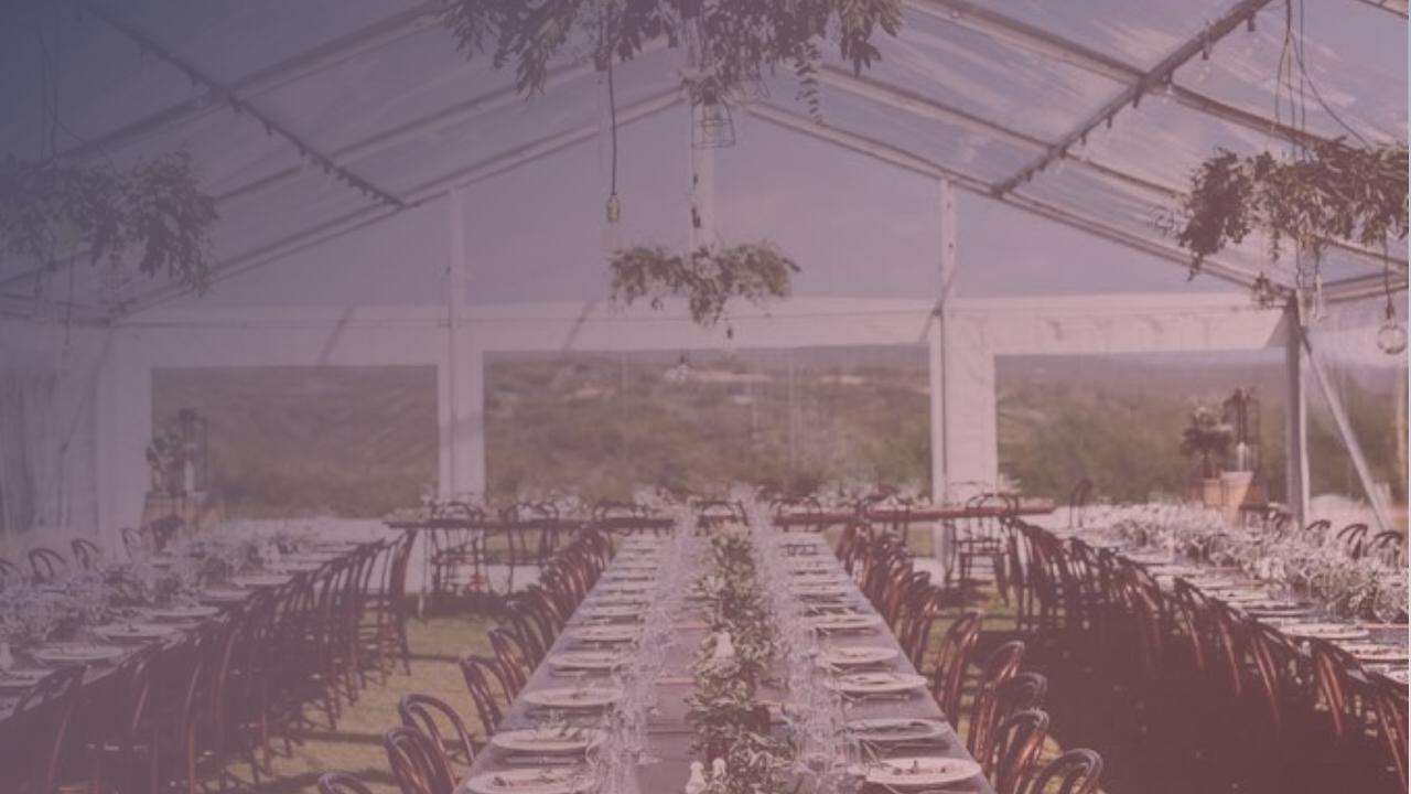Clear-roof wedding marquee with guests celebrating under lights