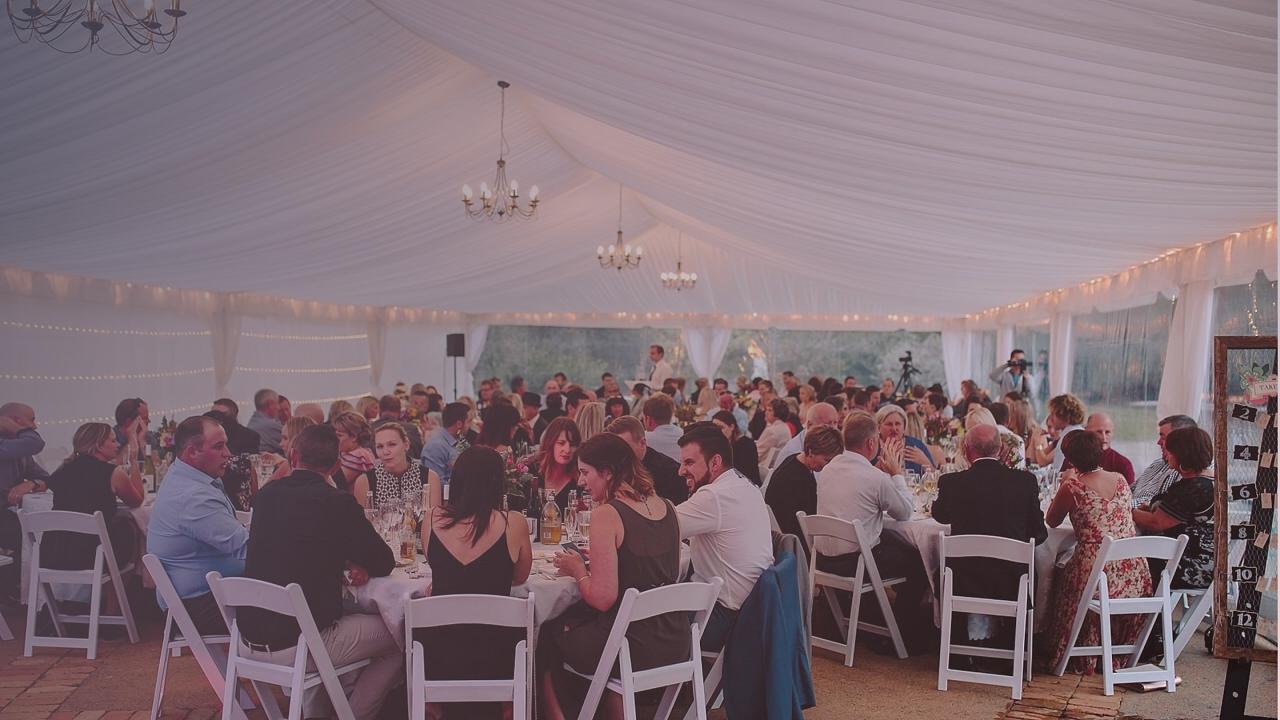 Elegant wedding marquee with festoon lighting and clear sides