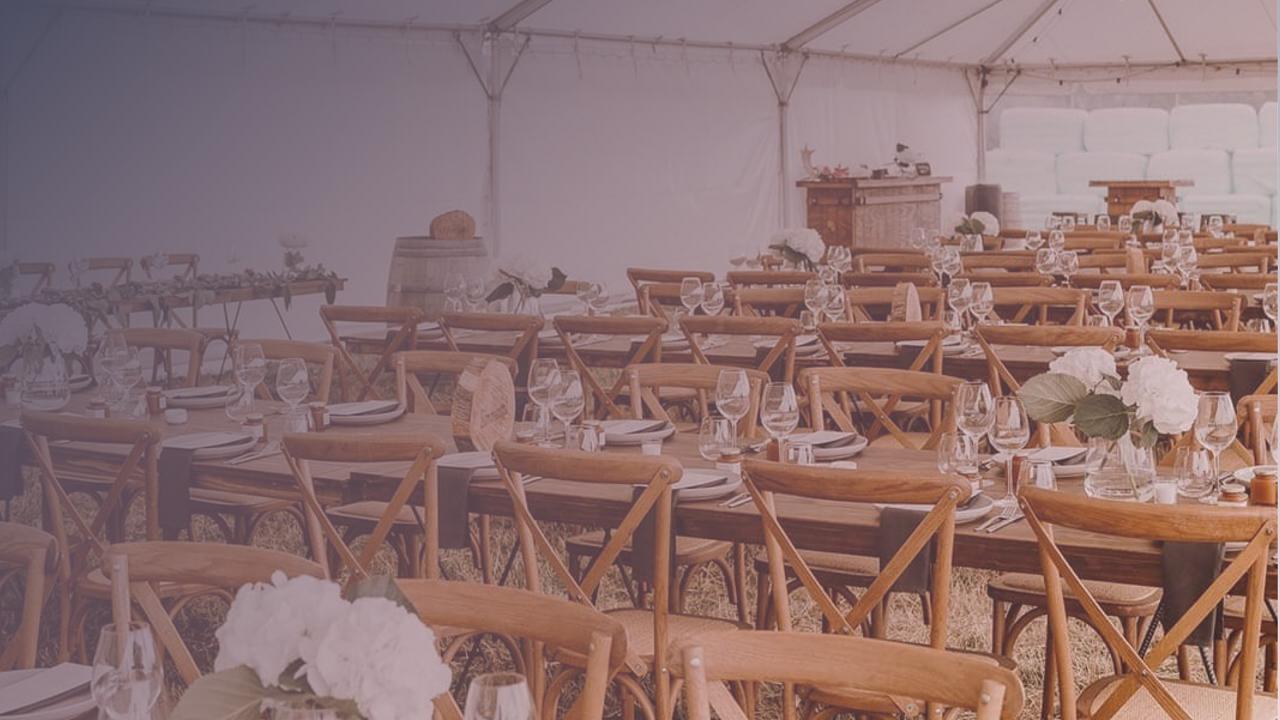 Complete wedding marquee setup with banquet tables, florals and lighting